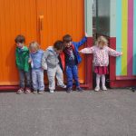 children stood outside colourful sheds