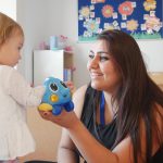 Staff member playing with little girl