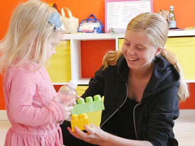 Staff member playing with little girl