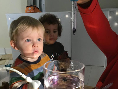 Boy exploring water and colur at Hovw Village Day Nursery