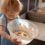 Child ready to bake bread