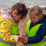 Two children looking at shells