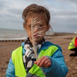 Child looking at feather on beach