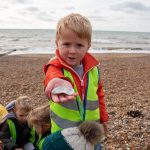 Child showing shells on the beach