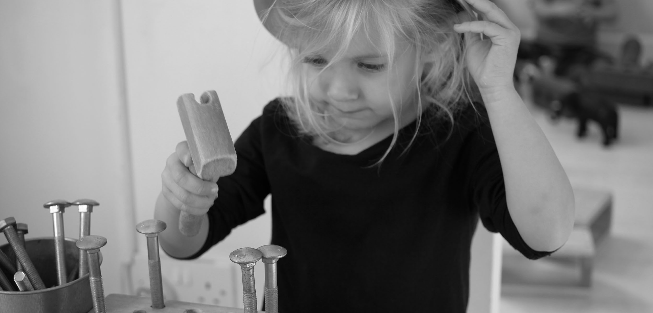 Child with toy hammer and nails