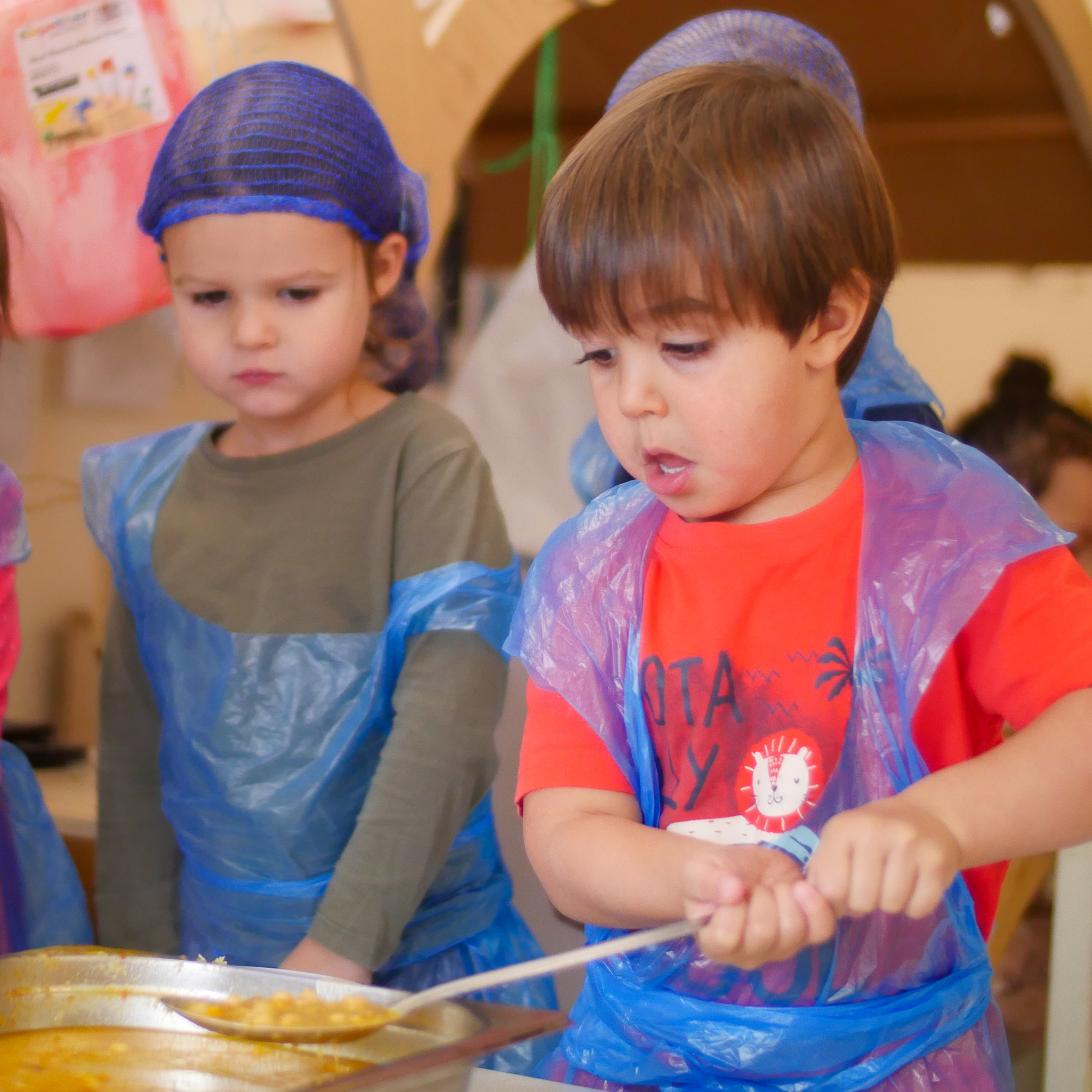 boy spoons curry out of saucepan