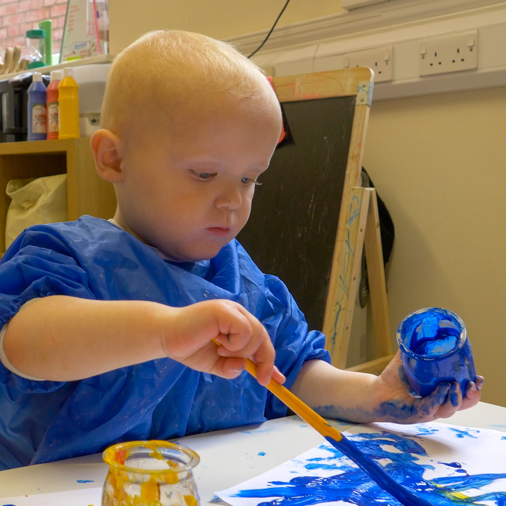 boy painting with blue paint