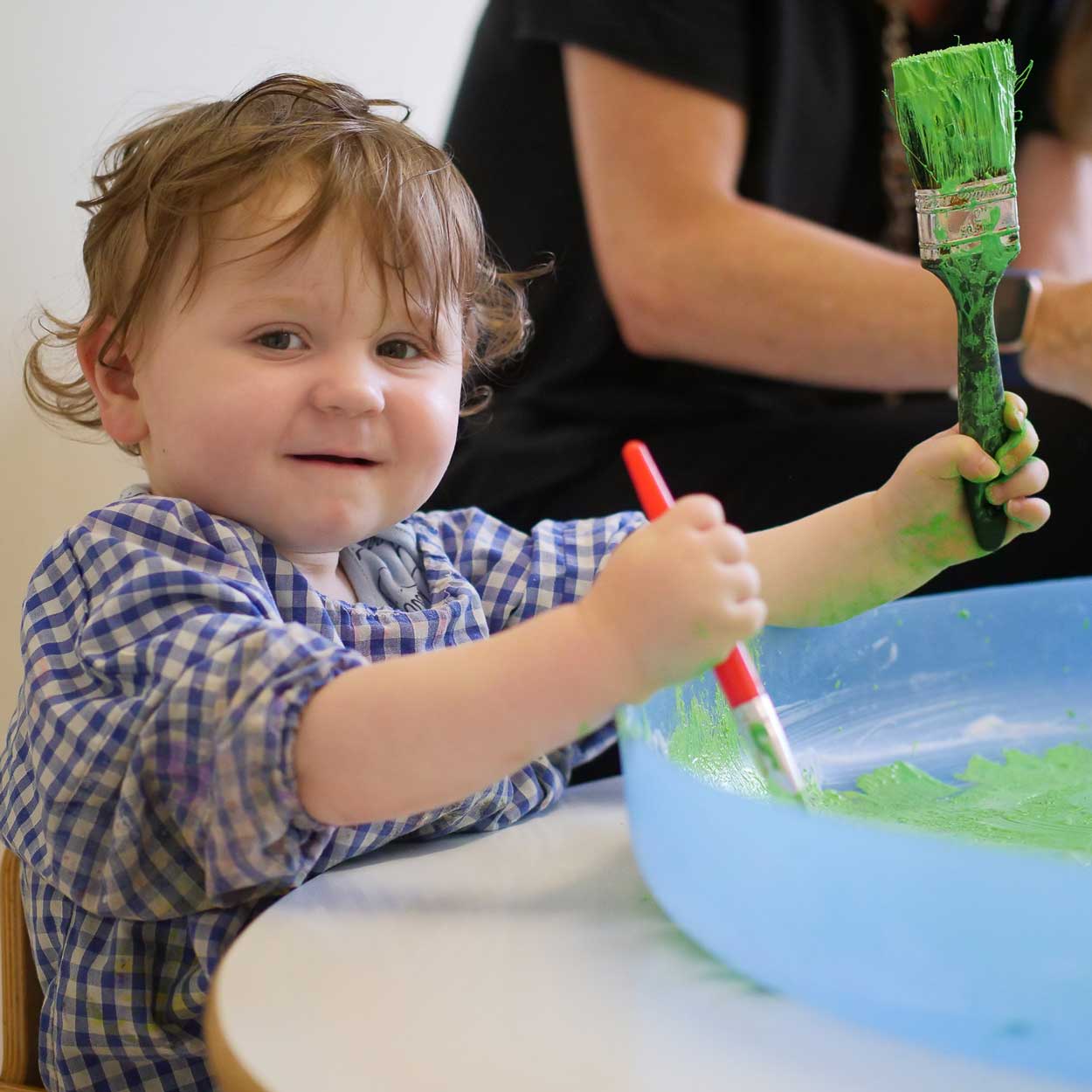 boy-holding-paint brush with green paint