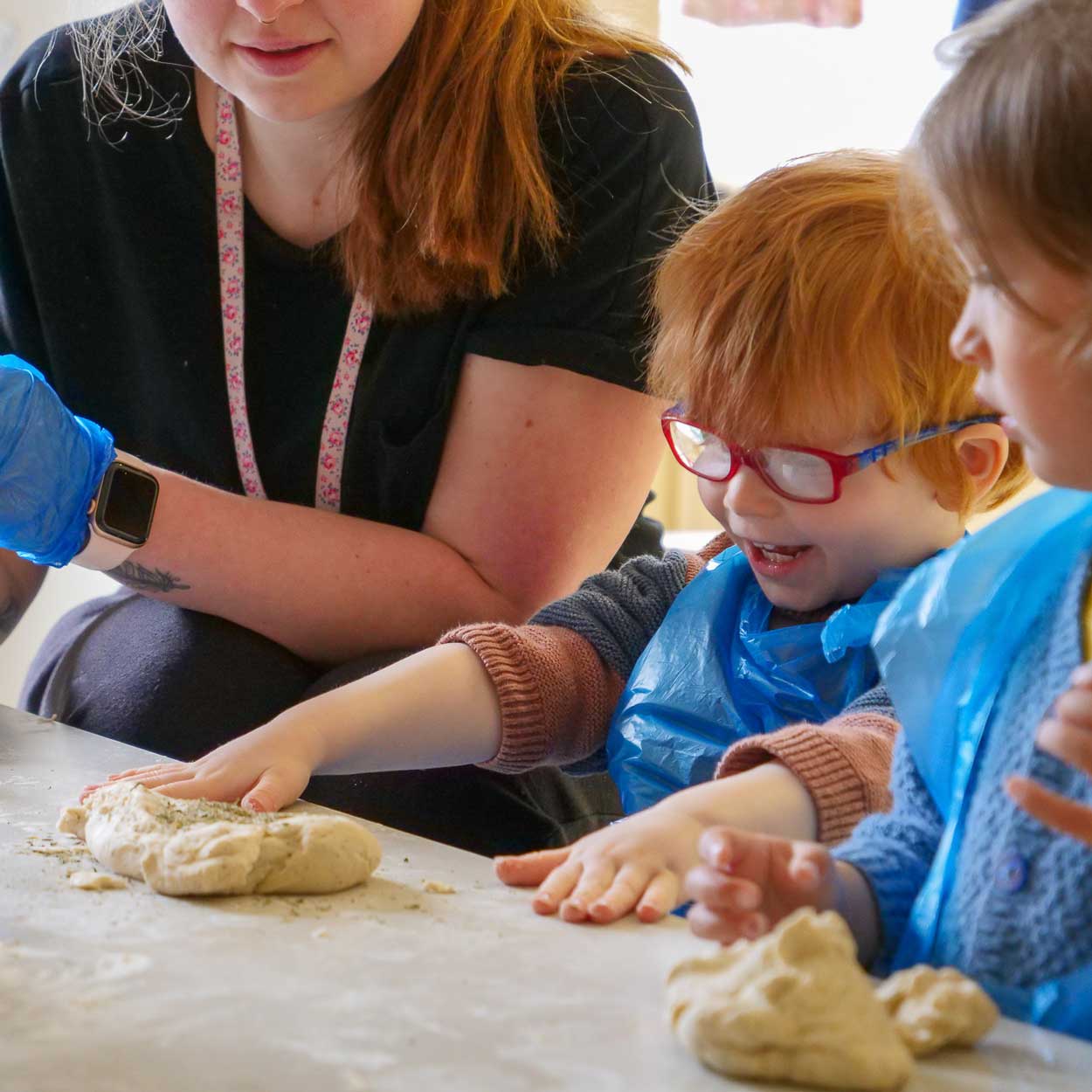 boy playing with bread dough on table