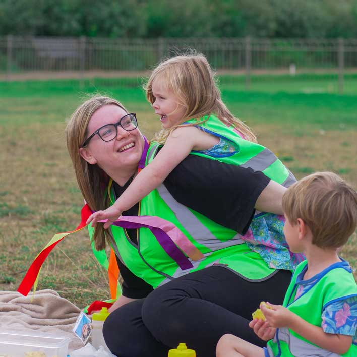 educator with child on back both smiling