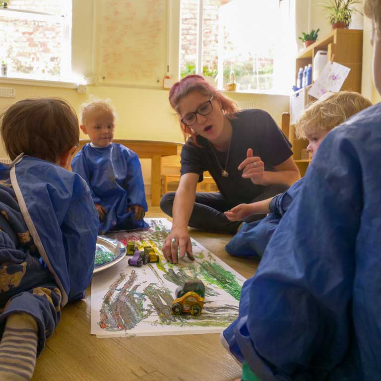 educator with children painting