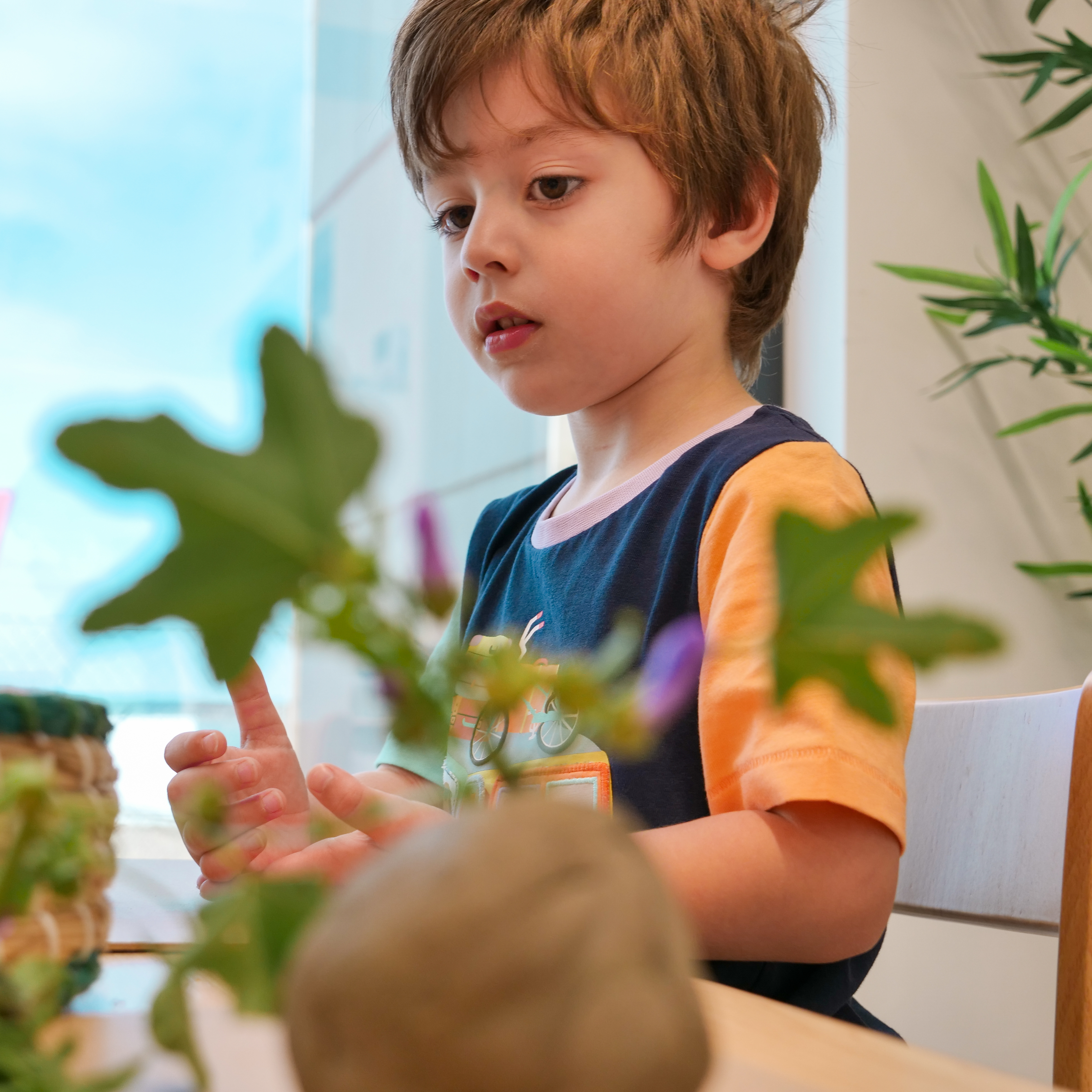 child playing with clay and leaves