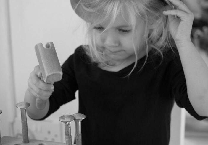 Child with toy hammer and nails